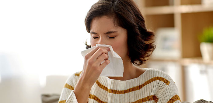 Woman holding a tissue to her nose