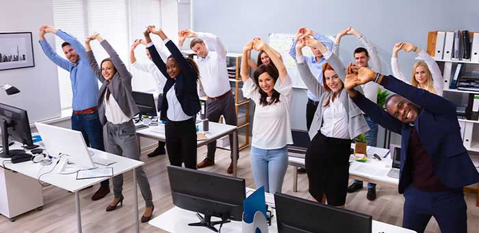 office team stretching together under guidance of La Verne chiropractor